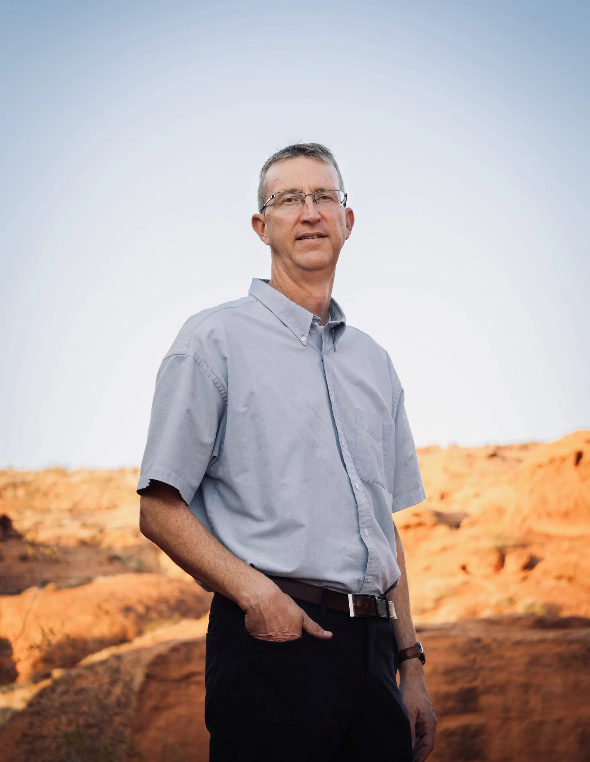 Dr. Jared Szymanski in Southern Utah, standing in front of a red rock landscape.